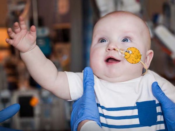 Niño sonriente en casa tras ser el primer paciente tratado con terapia génica CRISPR para una enfermedad metabólica rara.