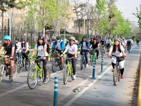 Estudiantes y trabajadores pedaleando por ciclovía en Santiago durante hora punta.