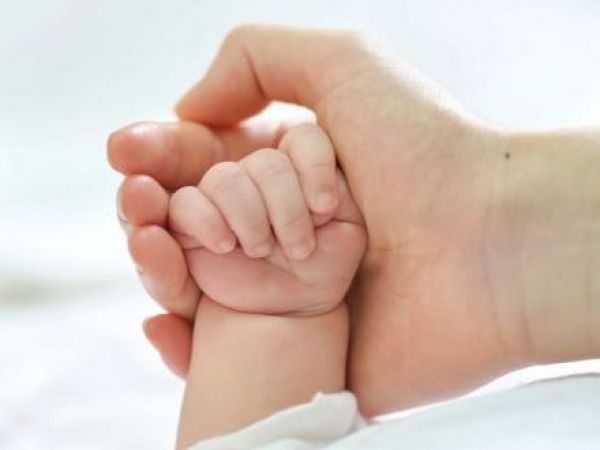 Mano de un bebé y persona adulta