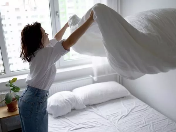 Mujer cambiando sábanas. Cada cuánto cambiar las sábanas de la cama
