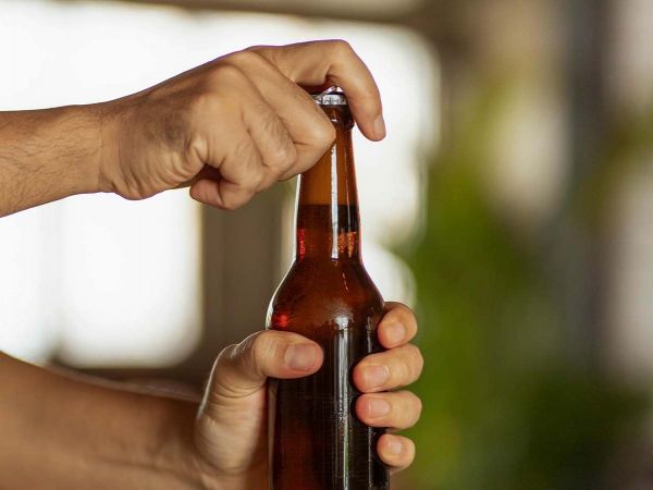 Botella de vidrio con tapa de plástico que genera microplásticos.