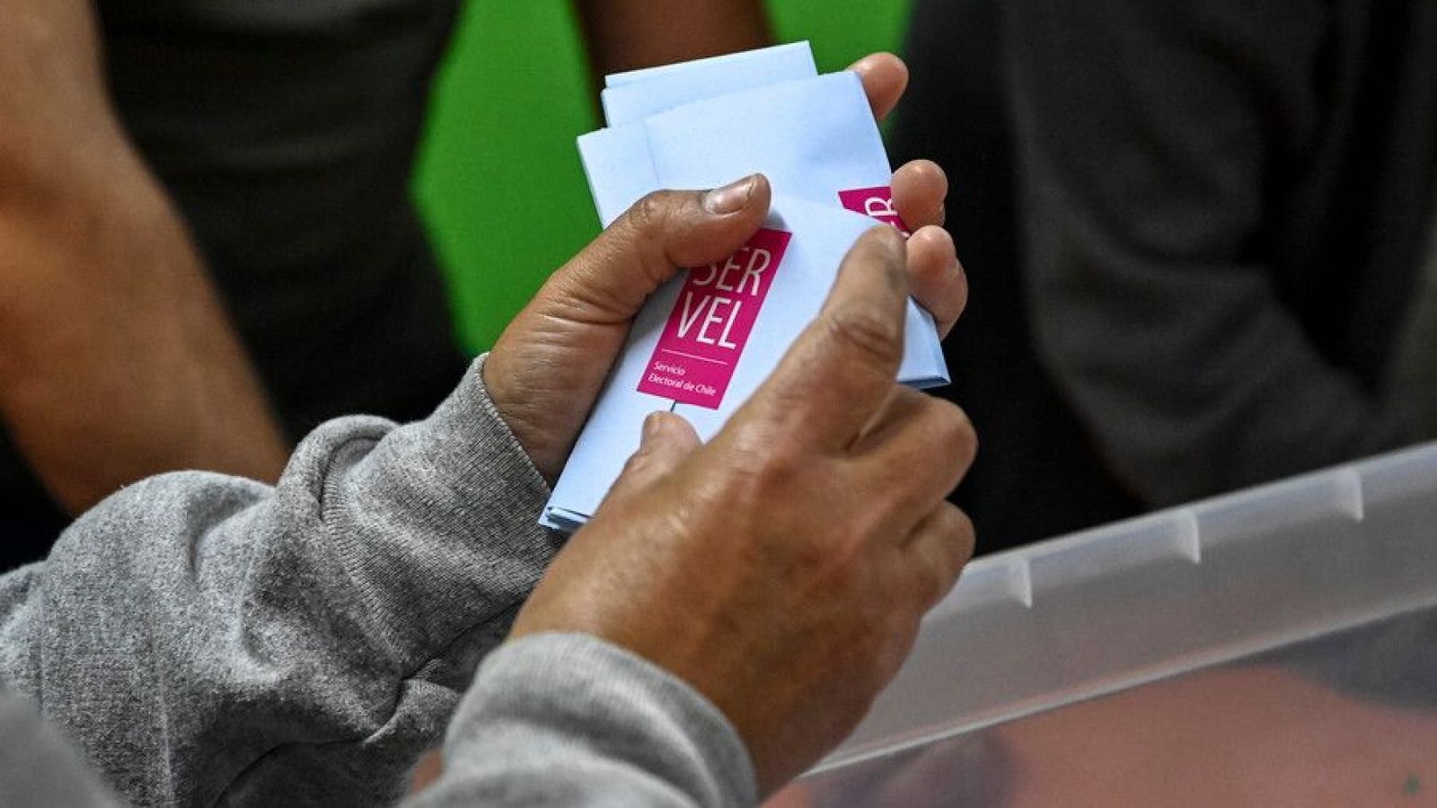 Persona sujetando votos electorales del Servel en sus manos