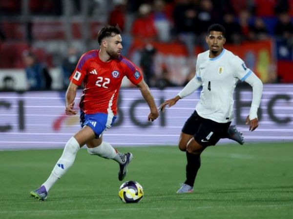 Ben Brereton y Ronald Araújo disputando un balón en el Estadio Nacional durante el partido entre Chile y Uruguay en las Eliminatorias Sudamericanas
