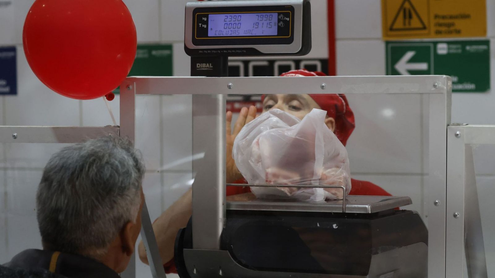 Trabajador pesando una bolsa de carne.