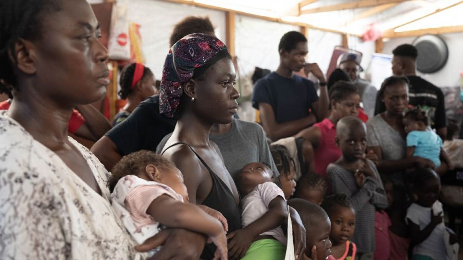 Haitianos/personas desplazadas recibiendo comida en un refugio en Puerto Príncipe (Haití)
