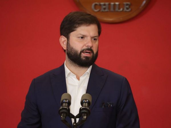 Presidente Gabriel Boric on fondo rojo en sus espaldas.