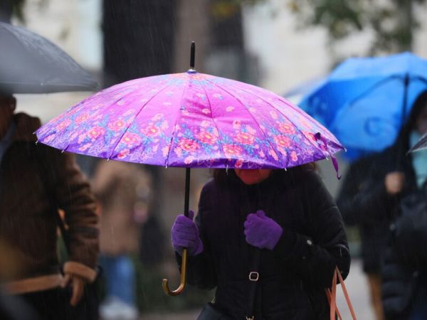 Persona bajo la lluvia en paraguas