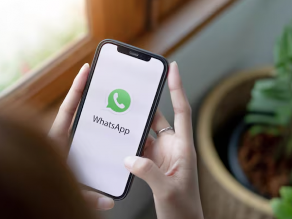 Manos tomando un celular con la aplicación de WhatsApp.