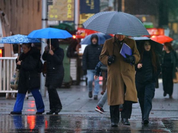 Personas bajo la lluvia en paraguas.