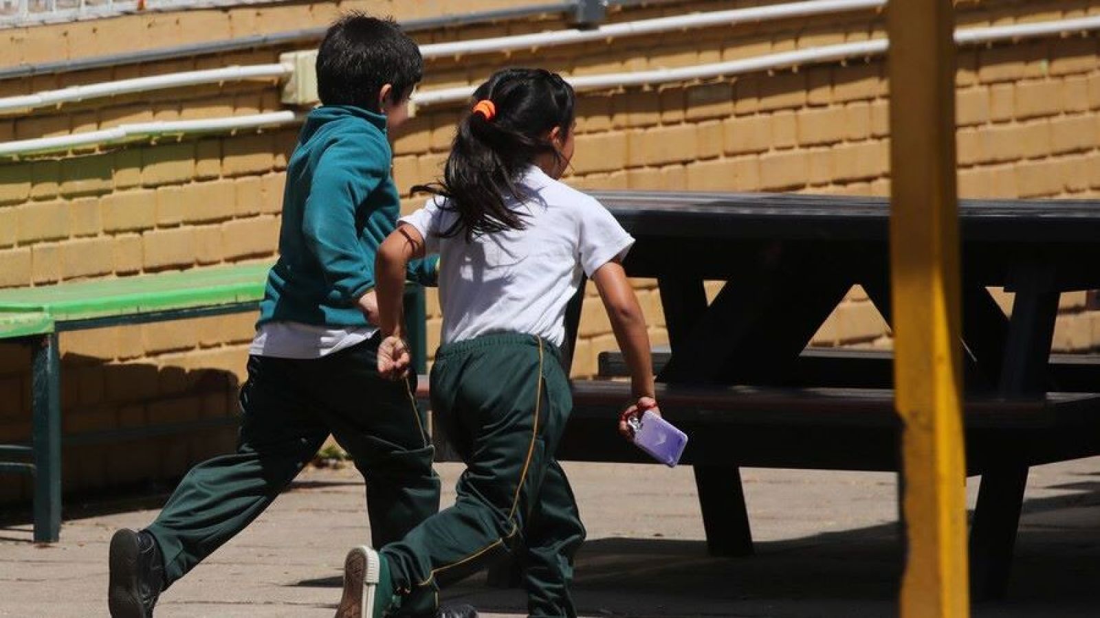 Niños corriendo en el patio de un colegio
