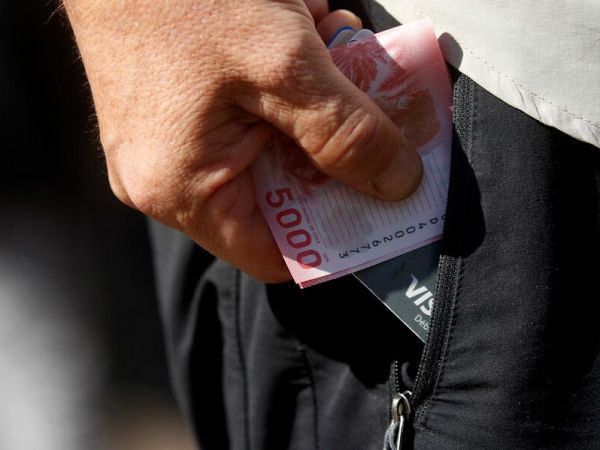 Foto referencial del Imacec. Mano con billetes