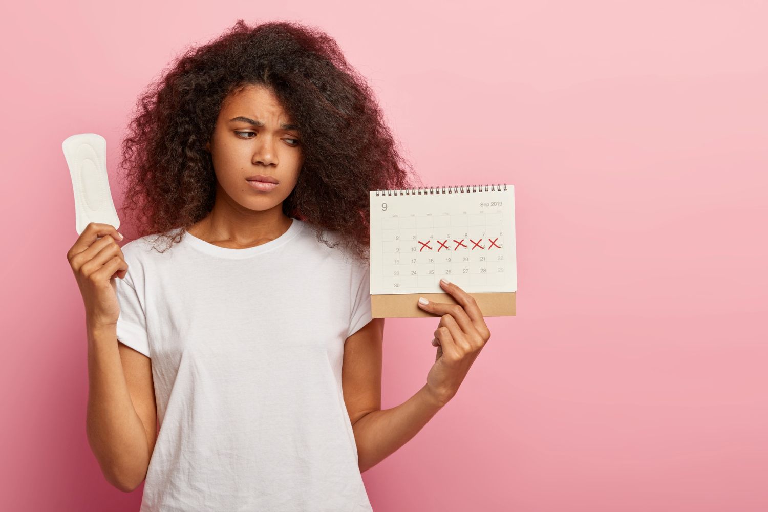 Mujer sujetando calendario menstrual