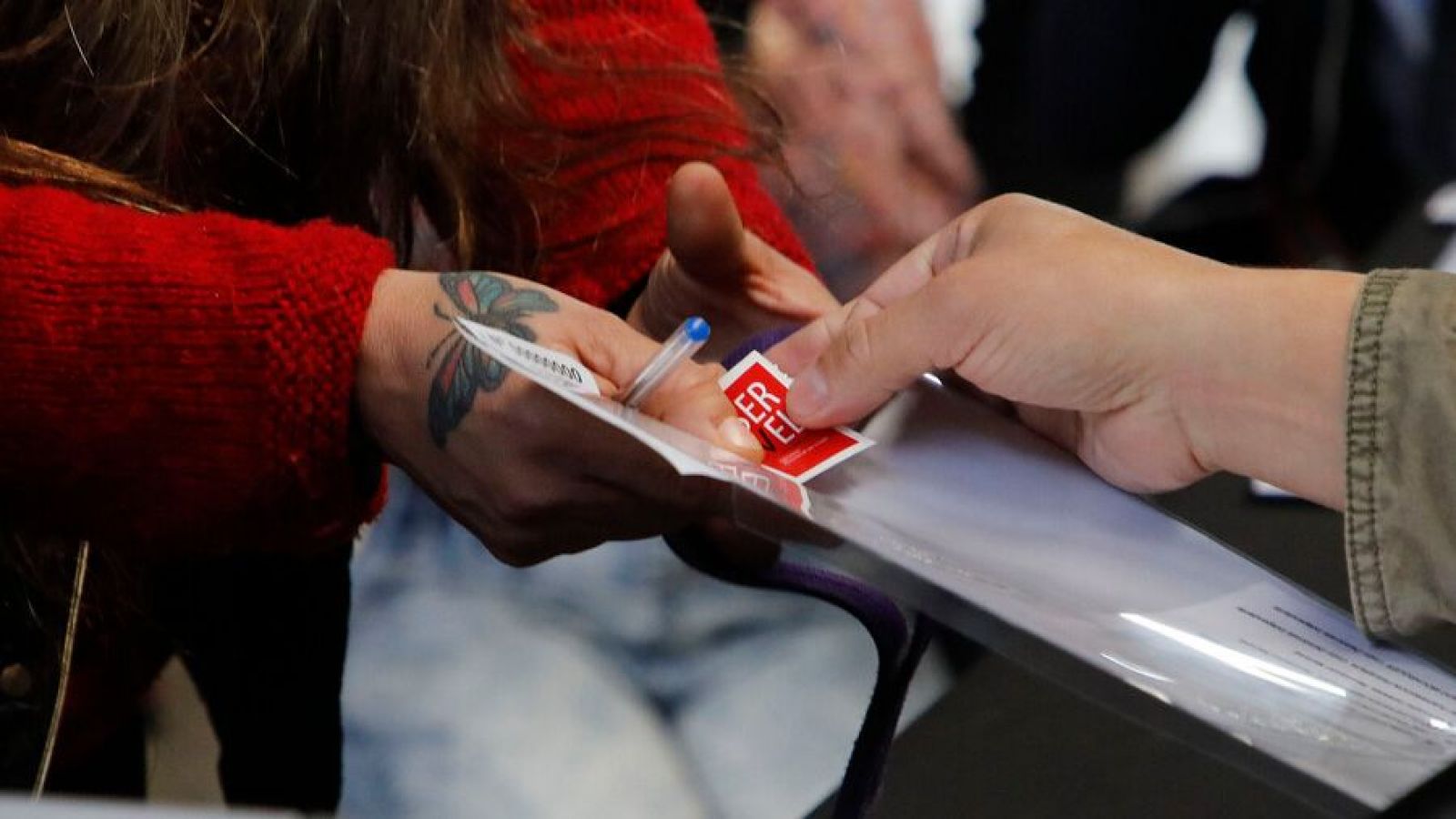 Mano recibiendo un voto en elecciones.