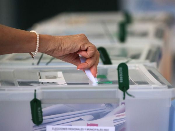 Mano emitiendo voto en una urna para elecciones