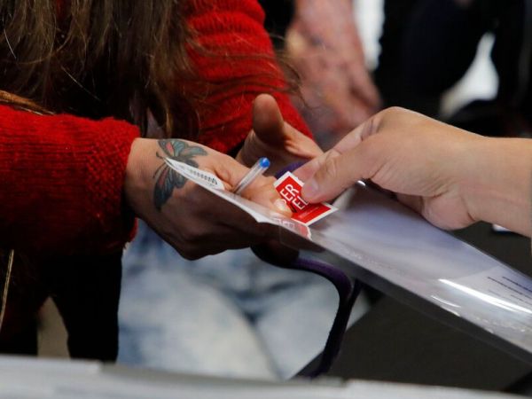 Mano recibiendo un voto en elecciones.