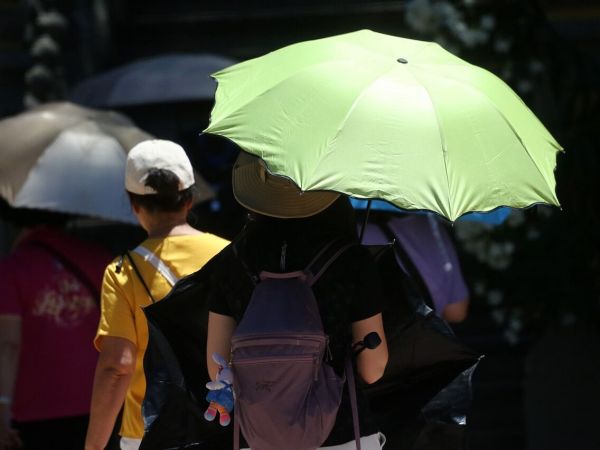 Persona con sombrilla bajo el sol en Santiago