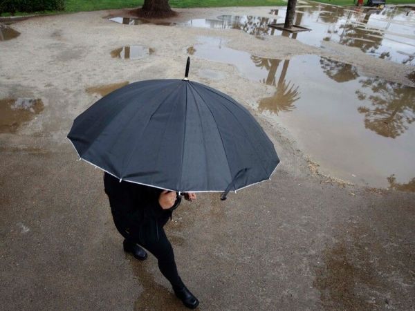 Persona bajo la lluvia con paraguas.