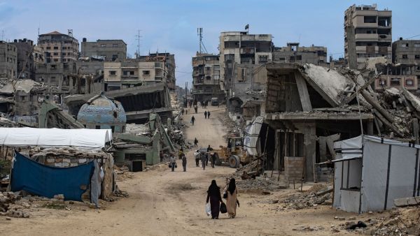 Mujeres caminando en Gaza mientras a su alrededor está todo destruido por la guerra.