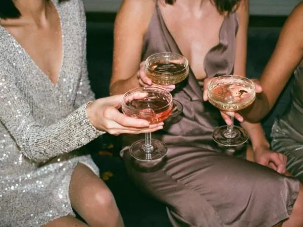 Mujeres con copas en la mano brindando.