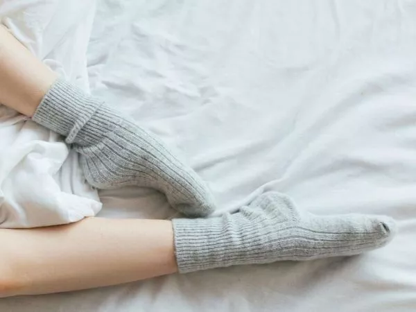 Persona durmiendo con calcetines. Foto referencial.