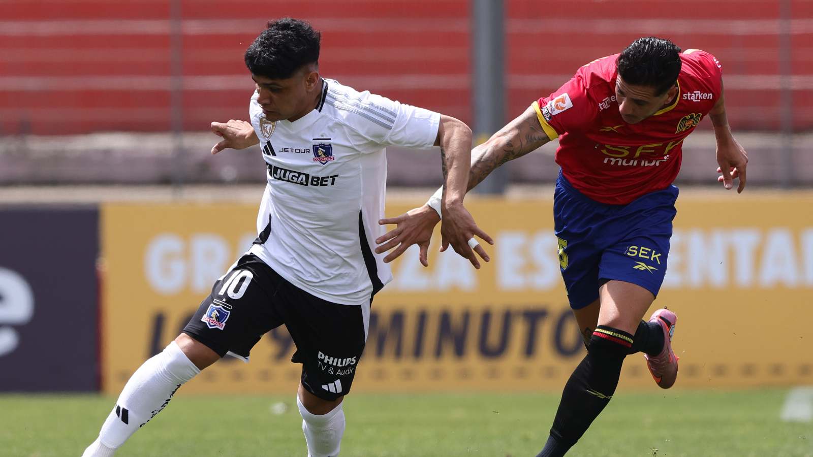 Claudio Aquino disputando el balón con Gonzalo Castellani en un duelo entre Colo Colo y Unión Española