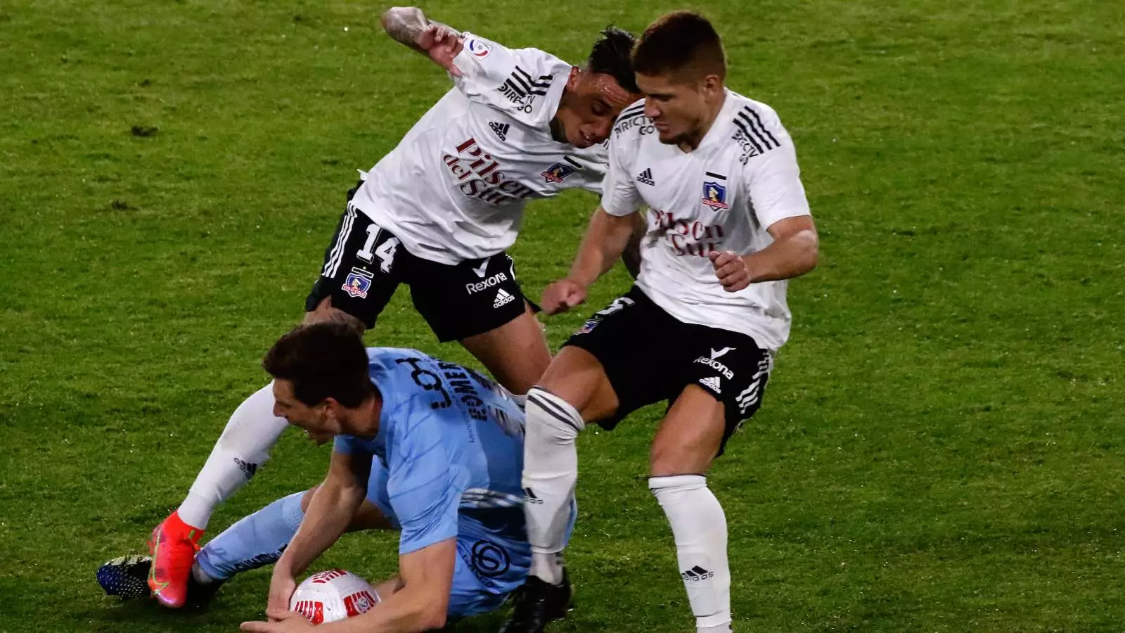 Martín Rodríguez y Leonardo Gil luchando un balón frente a un jugador de O'Higgins