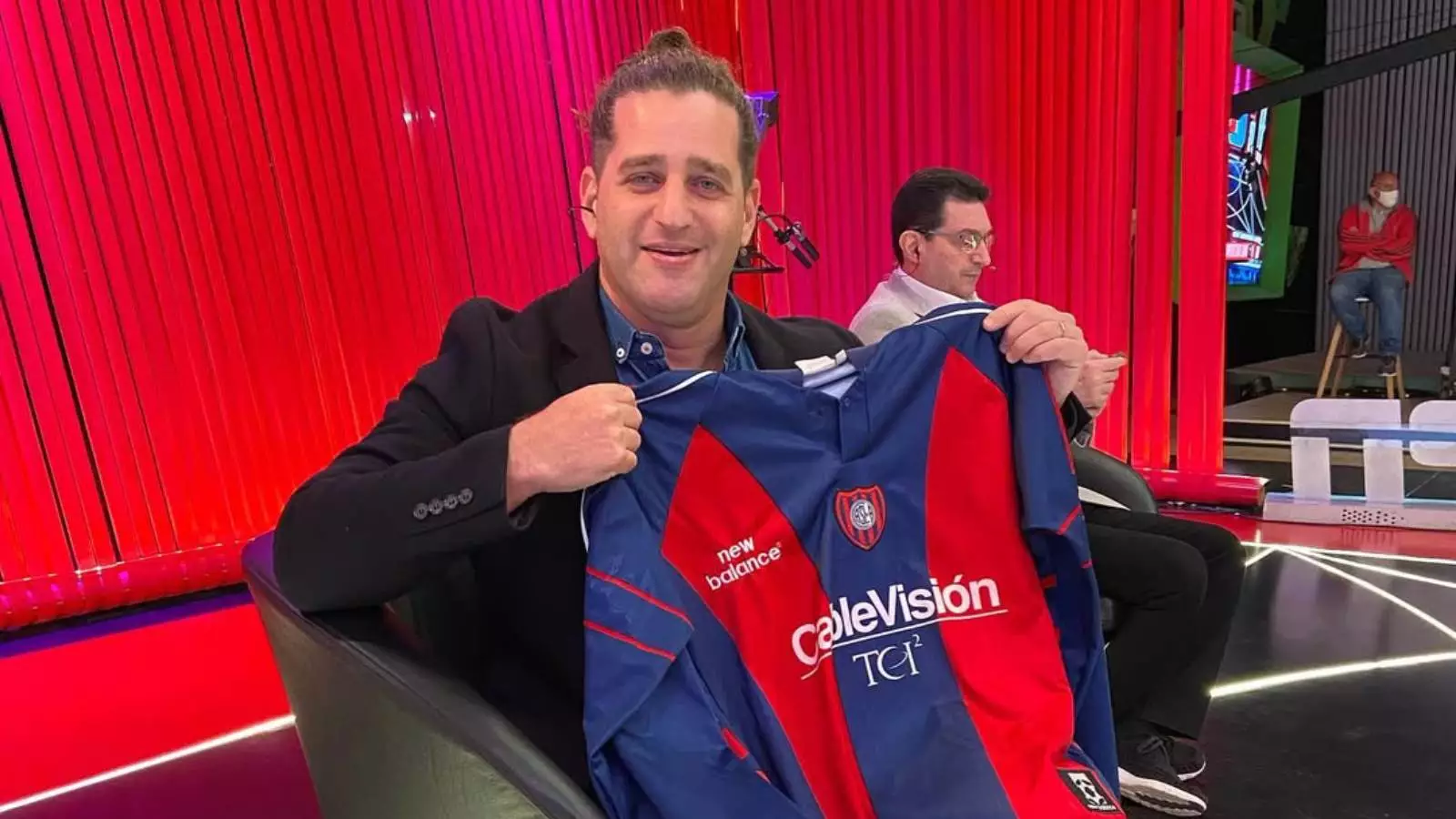 Damián Manusovich posando con una camiseta de San Lorenzo