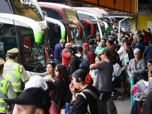 Personas esperando buses en terminal