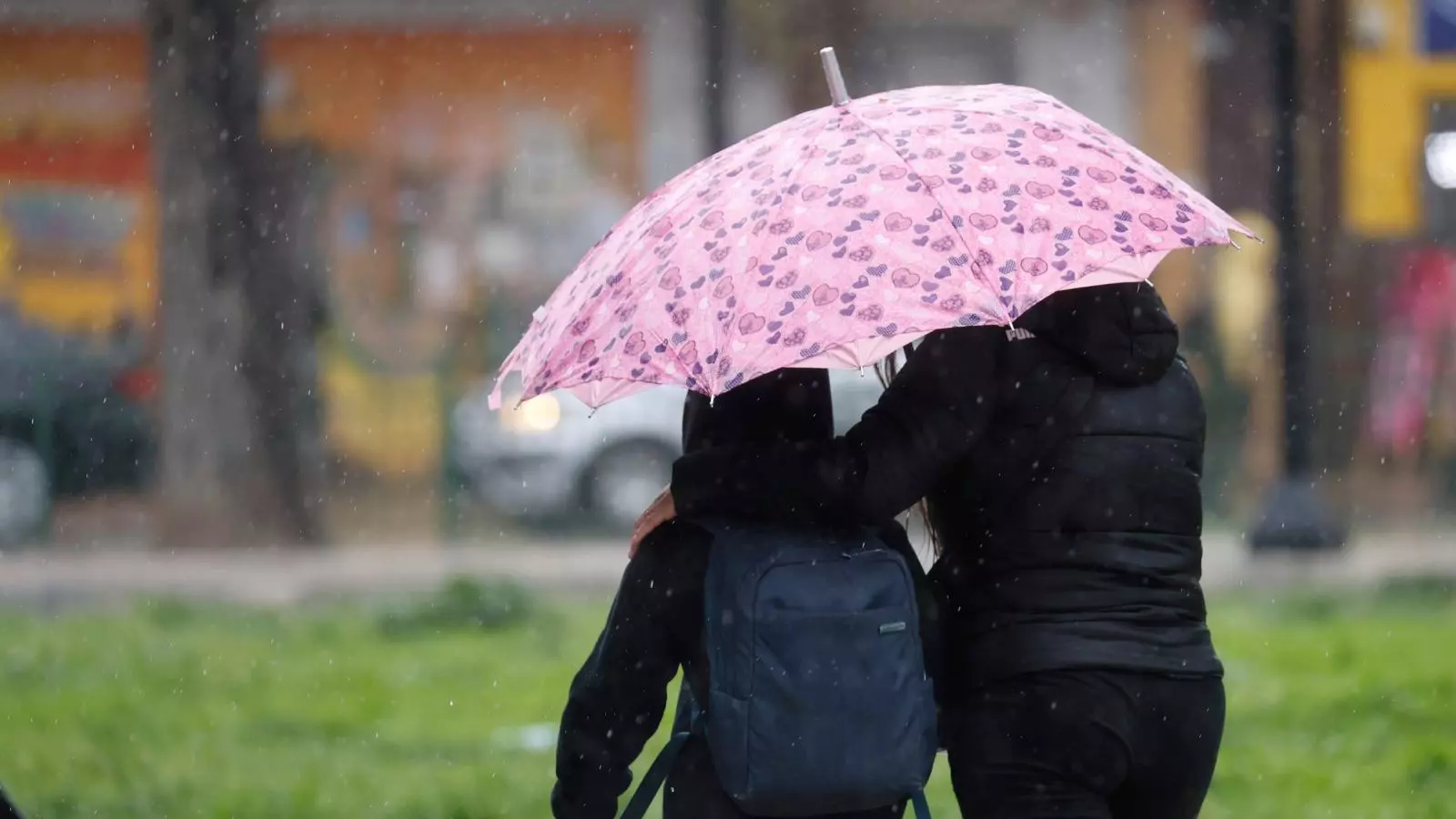 Personas bajo la lluvia con un paraguas