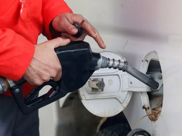 Persona cargando combustible en una bencinera
