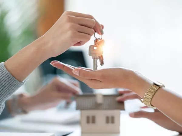 Persona entregándole las llaves de una casa a otra