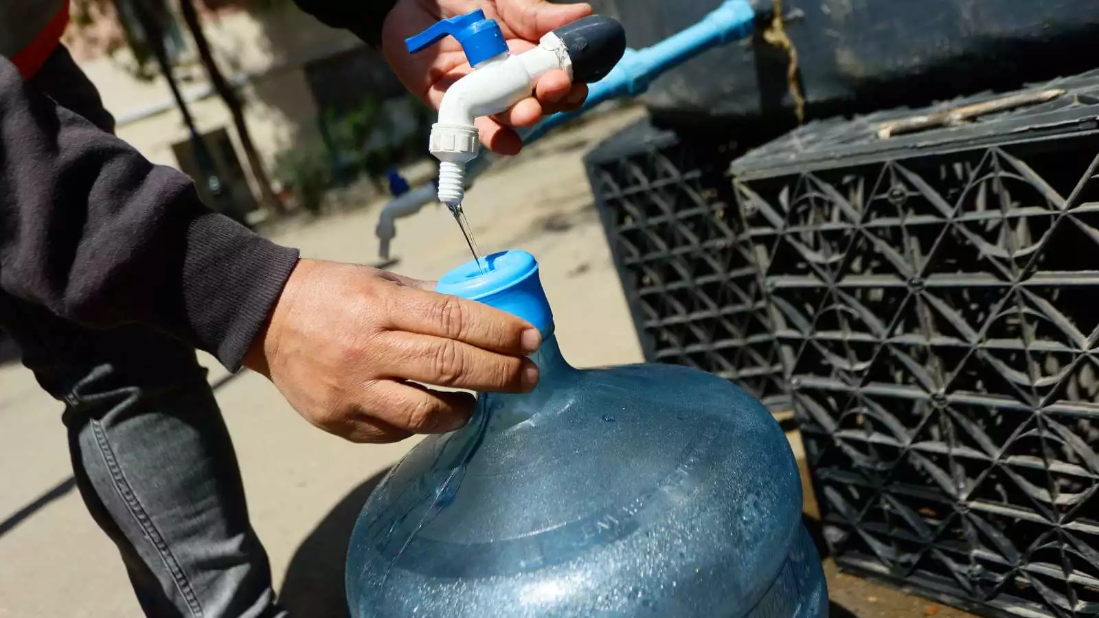 Persona llenando un bidón tras un corte de agua