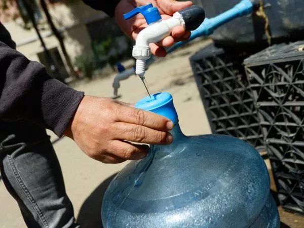 Persona llenando un bidón tras un corte de agua