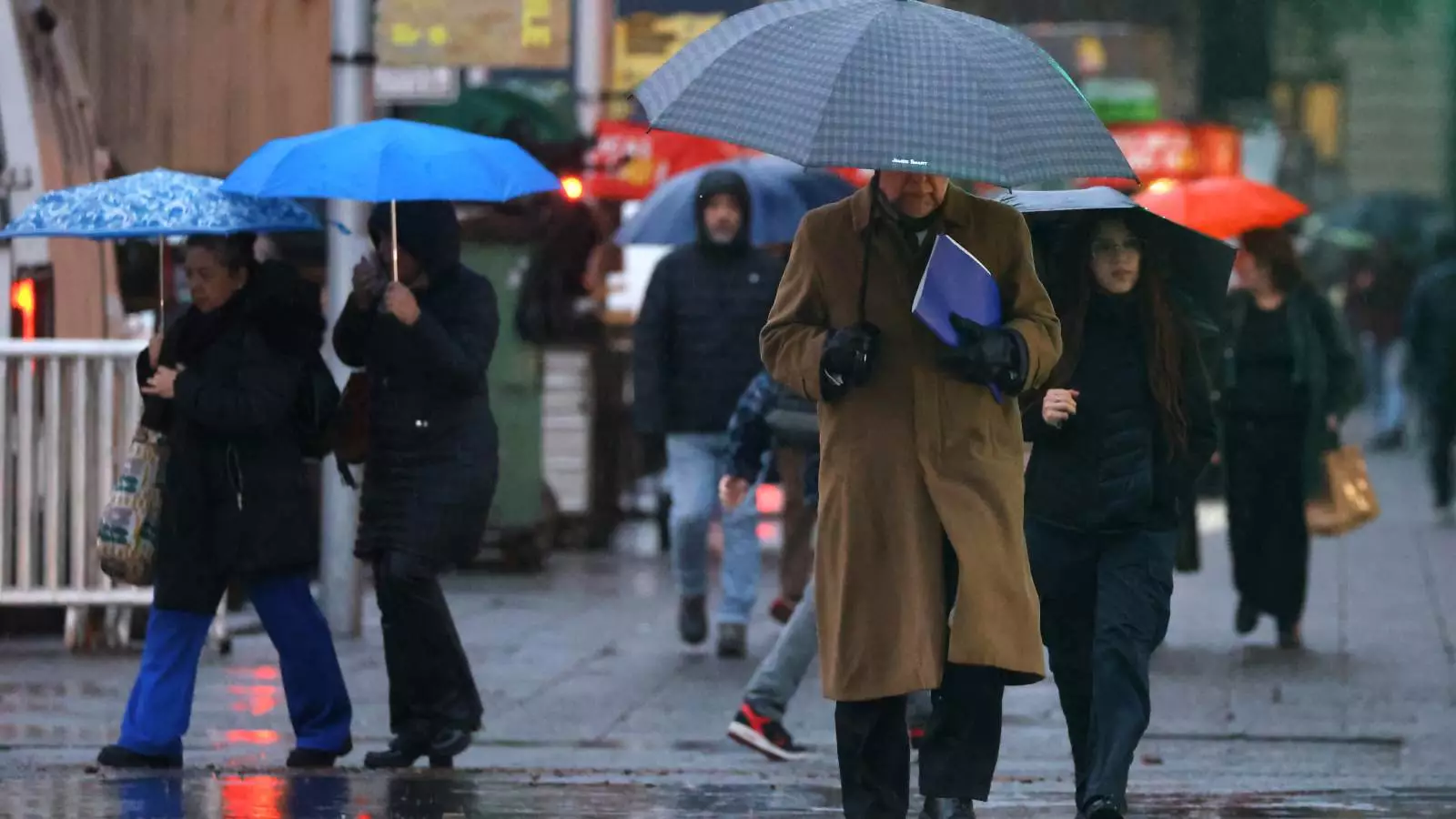 Personas con paraguas bajo la lluvia en Santiago