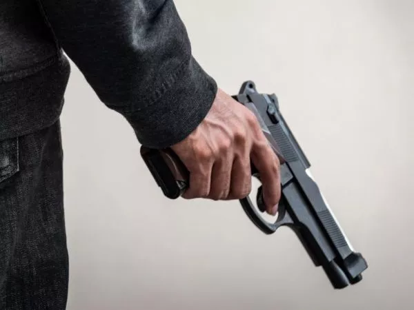 Persona sosteniendo una pistola