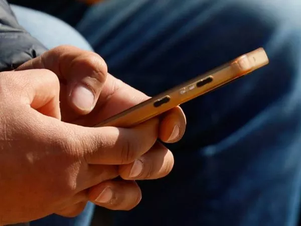 Persona con teléfono celular en la mano