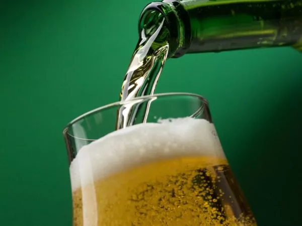 Persona sirviendo un vaso de cerveza