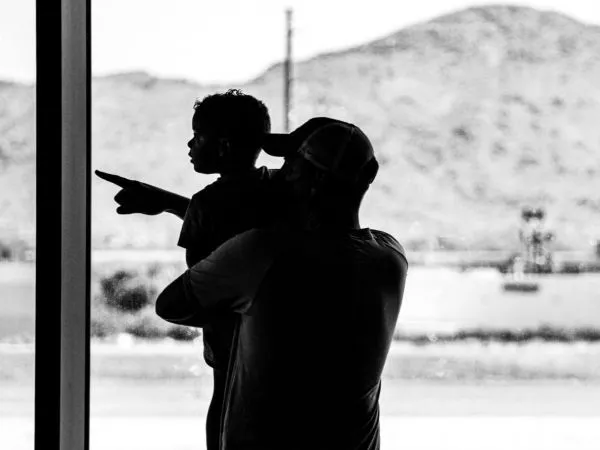 Niño y adulto en un aeropuerto en blanco y negro