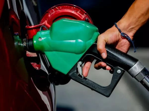 Persona cargando combustible en una bencinera