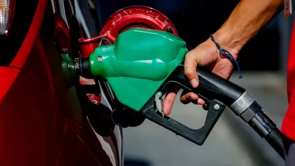 Persona cargando combustible en una bencinera