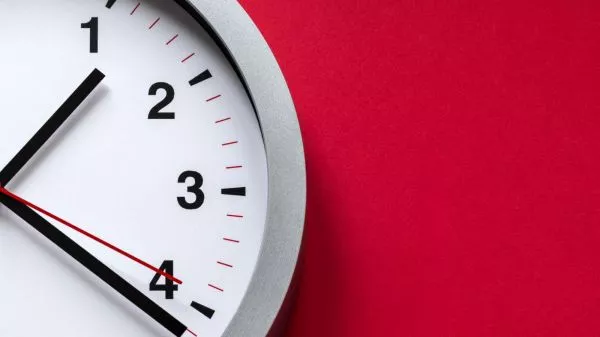 Reloj análogo sobre un fondo rojo